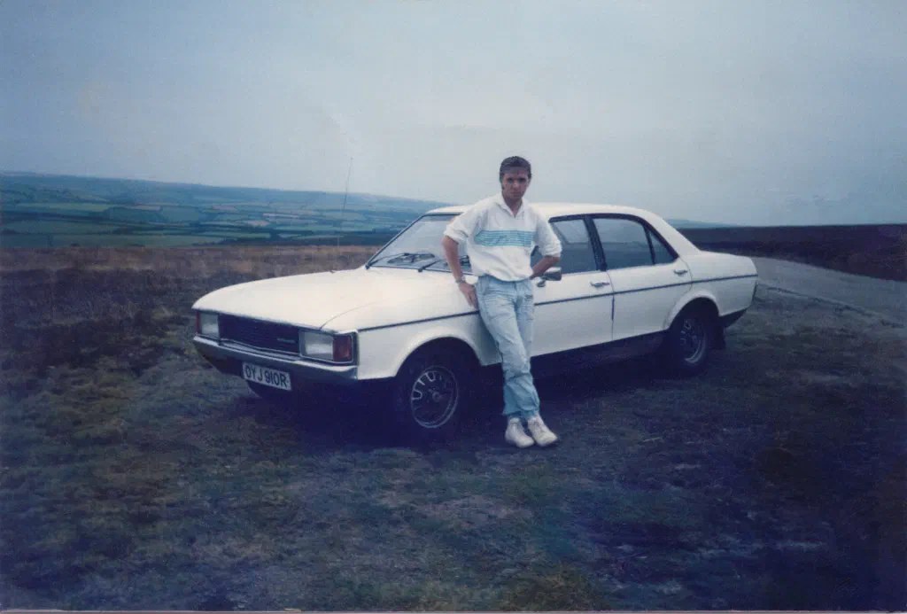 Alan at about 20 in the mid-1980s, slim at 70kg, leaning on a Ford Granada